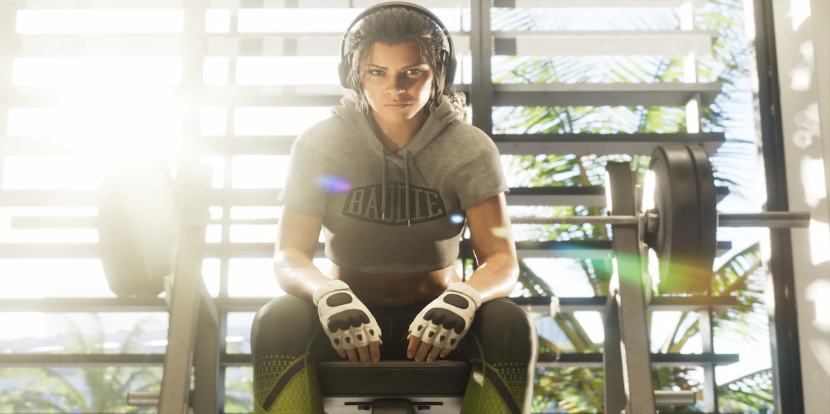 Lucia de GTA 6 sentada em um banco de academia com fones de ouvido e luvas de treino.
